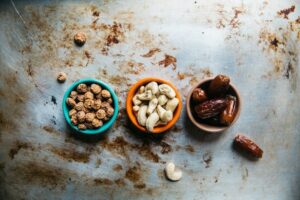 Three bowls of dried snacks and nuts on a weathered metal surface